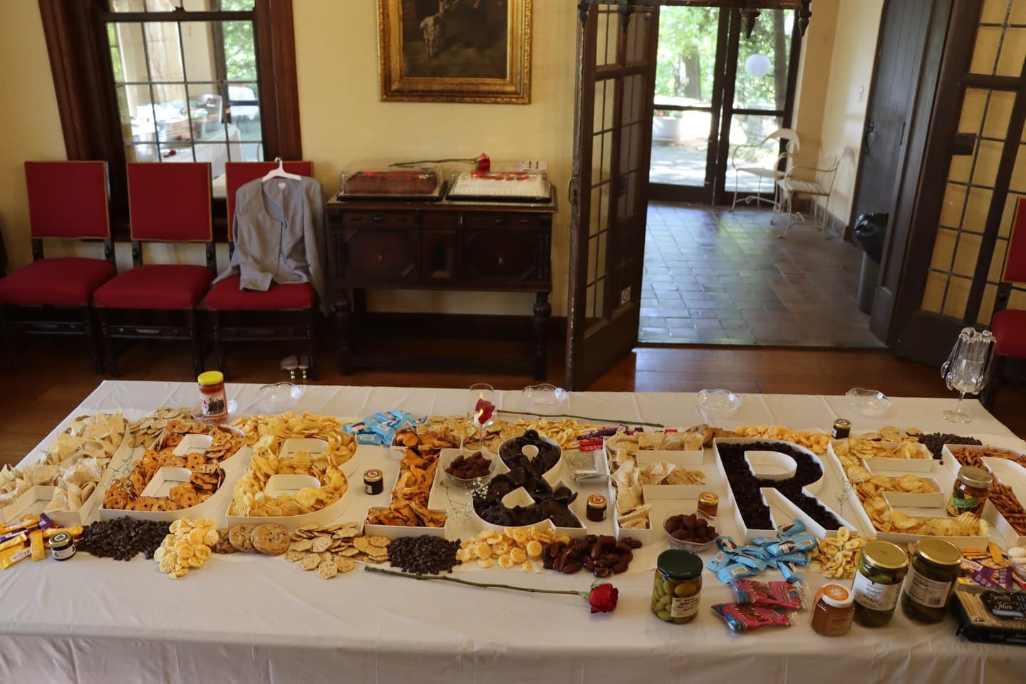 A long grazing table inside the Plummer House with snacks arranged into letters