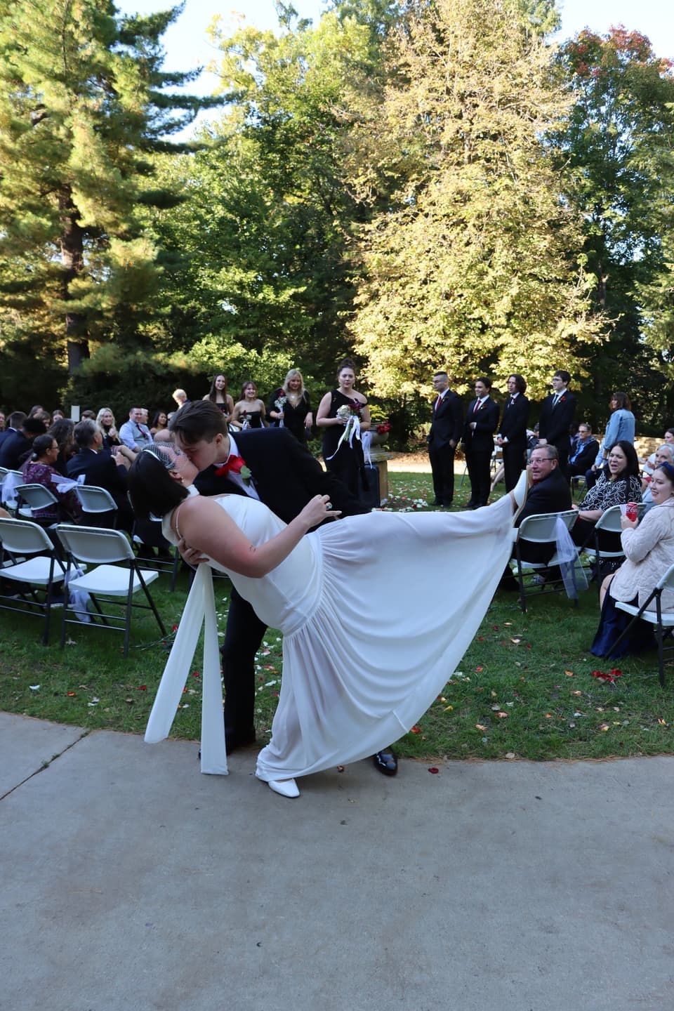 Fred dips Abbi for a kiss at the end of the aisle as guests cheer in the garden