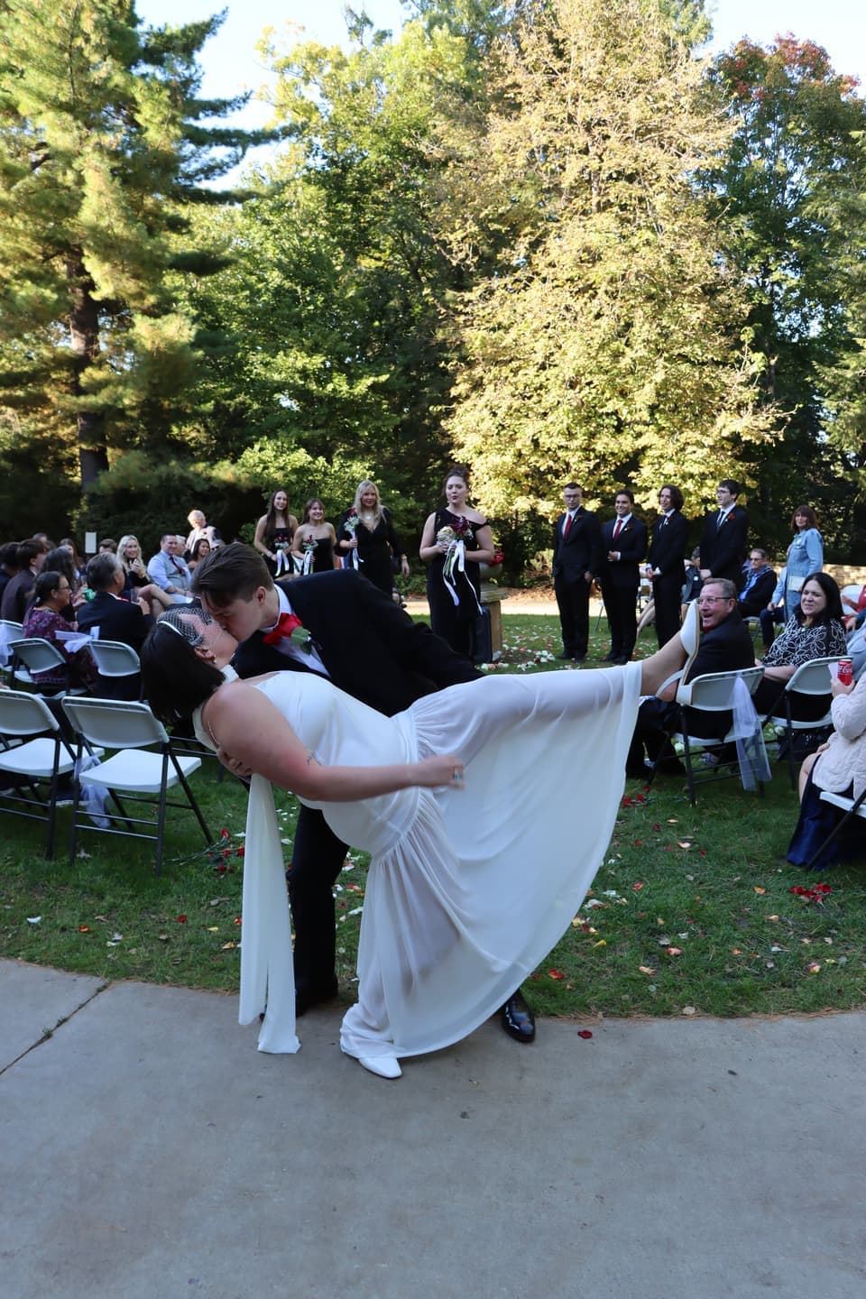 Closer view of the kiss at the end of the ceremony with guests seated behind